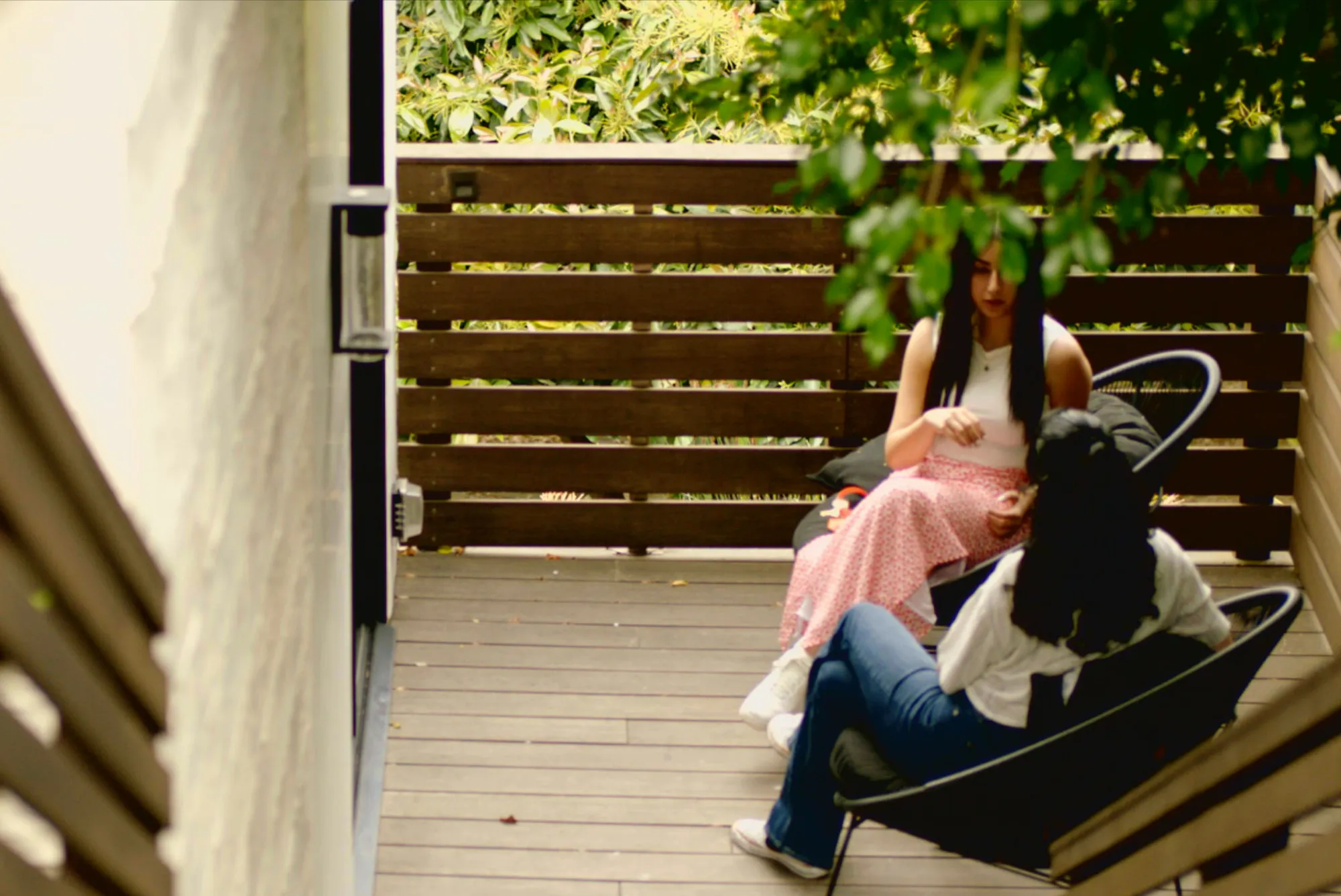 Two people sitting in a secluded outdoor patio discussing mental health treatment.